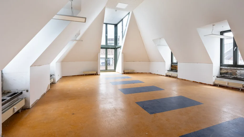Unausgebauter Dachgeschossbereich der zukünftigen Konferenzfläche während der Umbauarbeiten.